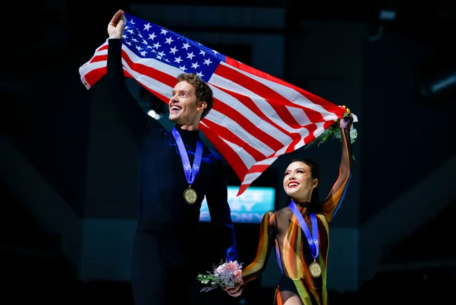 Madison Chock and Evan Bates of the United States take a victory lap with their gold medals after winning the Ice Dance Free Dance program during the ISU Four Continents Figure Skating Championships at Broadmoor World Arena.