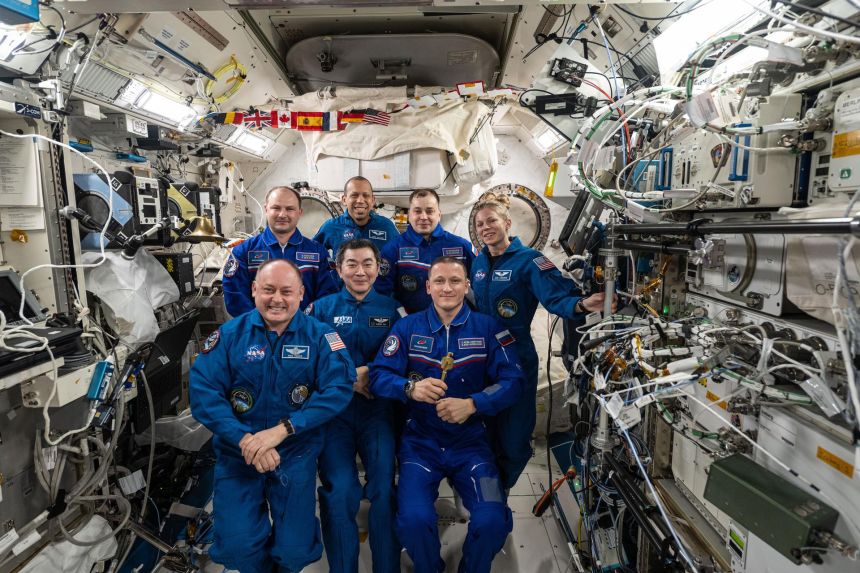 The Expedition 74 crew gathers for a portrait aboard the International Space Station in January, when NASA astronaut Mike Fincke (front left) handed over command of the orbital outpost to Roscosmos cosmonaut Sergey Kud-Sverchkov (front right).