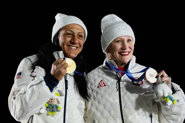 United States' gold medalist Elana Meyers Taylor, left, and United States' bronze medalist Kaillie Armbruster Humphries, right, pose with their medals after the women's monobob competition at the 2026 Winter Olympics, in Cortina d'Ampezzo, Italy, Monday, Feb. 16, 2026. (AP Photo/Alessandra Tarantino)