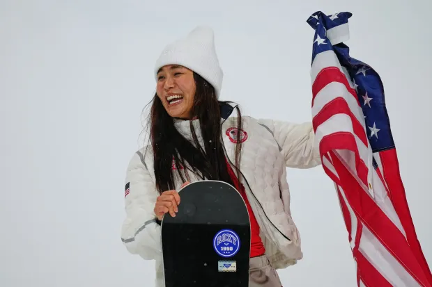 Silver medalist Chloe Kim laughs while trying to display the American flag after the women's snowboarding halfpipe finals at the 2026 Winter Olympics on Thursday, Feb. 12, 2026, in Livigno, Italy. (AP Photo/Abbie Parr)