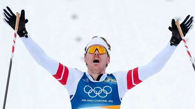 Ben Ogden of the United States crosses the finish line to win the silver medal in the cross-country skiing men's sprint classic at the 2026 Winter Olympics on Tuesday, Feb. 10, 2026, in Tesero, Italy. (AP Photo/Matthias Schrader)