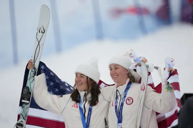 Silver medalist Jaelin Kauf, left, and bronze medalist Elizabeth Lemley, both of the United State, celebrate after the women's freestyle skiing dual moguls finals at the Winter Olympics on Saturday, Feb. 14, 2026, , in Livigno, Italy. (Abbie Parr/AP)