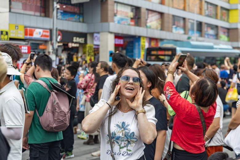 A Serbian tourist has fun at the viewing platform around the Liziba Station of Chongqing Rail Transit in Yuzhong District of southwest China's Chongqing, on October 3, 2025.