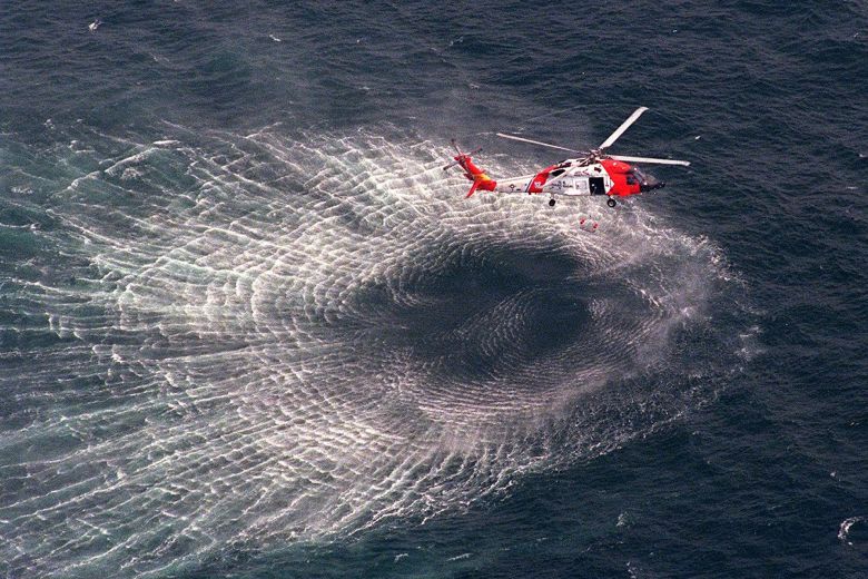 A Coast Guard helicopter lifts a rescue swimmer on July 17, 1999 in the search for debris from John Kennedy Jr.'s plane.