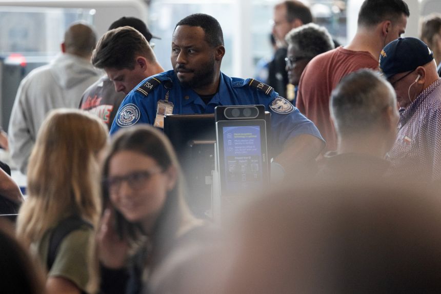 A TSA officer checks passports as passengers wait in long TSA lines at the George Bush Intercontinental Airport in Houston on Wednesday.