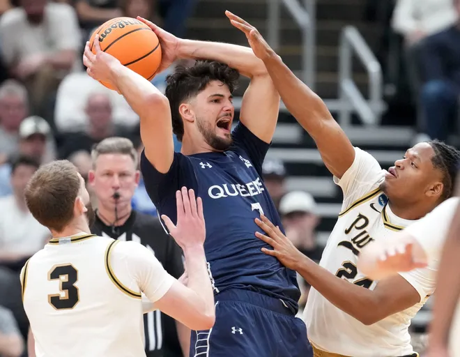 Purdue Boilermakers guard Braden Smith (3) and forward Trey Kaufman-Renn (4) defend Queens University of Charlotte Royals forward Gus Larson (7) as he looks to pass the ball during a NCAA Tournament first round game Friday, March 20, 2026, at Enterprise Center in St. Louis. Purdue defeated Queens 104-71.