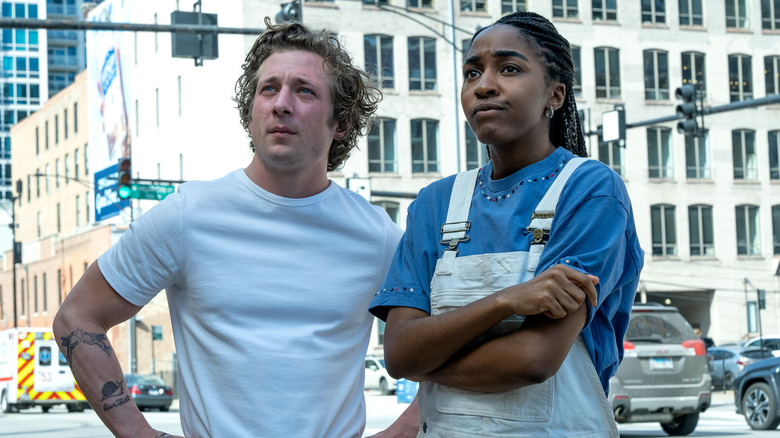 Carmy Berzatto (Jeremy Allen White) and Syd Adamu (Ayo Edebiri) stare discerningly on the street in The Bear