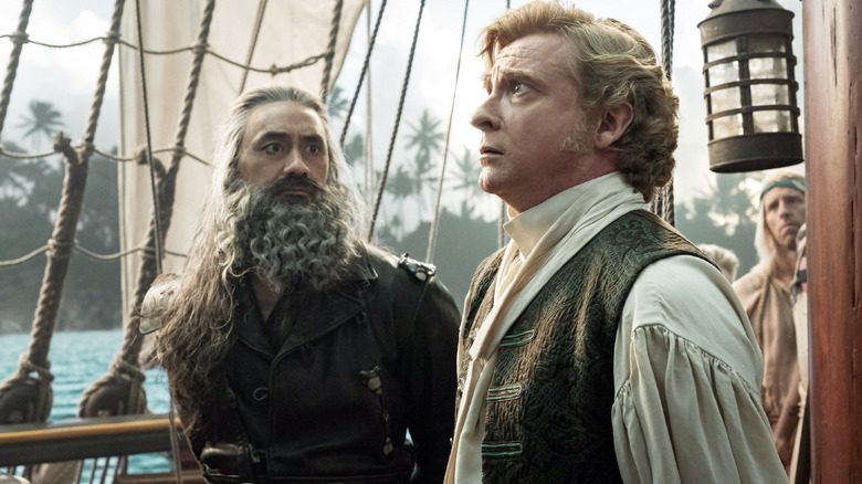 Edward Teach (Taika Waititi) stares intently at Stede Bonnet (Rhys Darby) in Our Flag Means Death