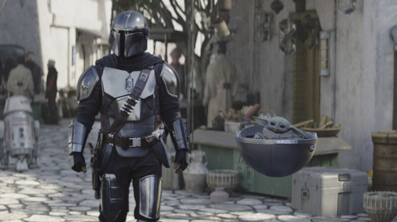 Din Djarin (Pedro Pascal) walks with Grogu in The Mandalorian