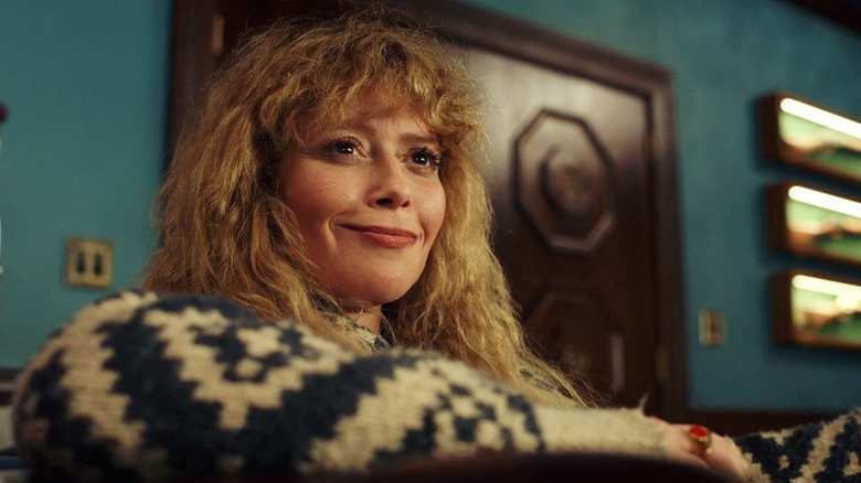 Charlie Cale (Natasha Lyonne) sits smiling confidently in Poker Face