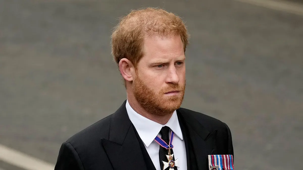 Prince Harry walking at Westminster Abbey in a dark suit