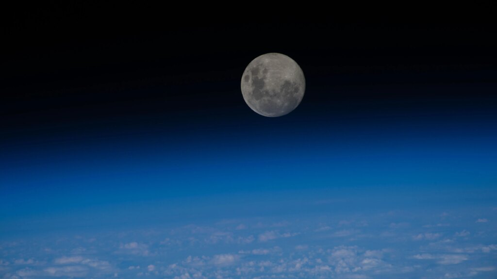 iss070e047294 (Dec. 26, 2023) -- The last full moon of 2023, the "Cold Moon," sits just above the blue glow of Earth's horizon as the International Space Station orbited nearly 270 miles over the Pacific Ocean.