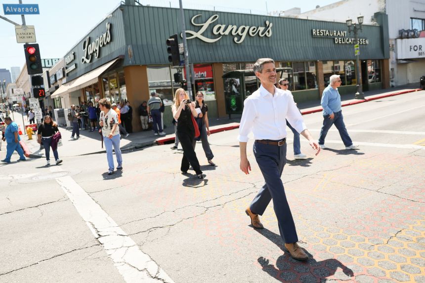 Mahan walks across Alvarado Street following a campaign event outside Langer's Deli in neighborhood of Los Angeles on April 24, 2026.