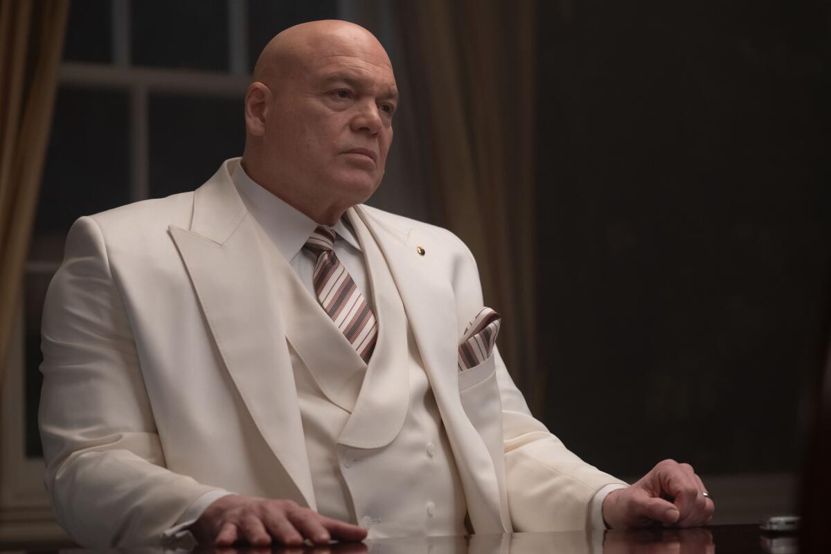 Wilson Fisk in a white suit sitting at a desk