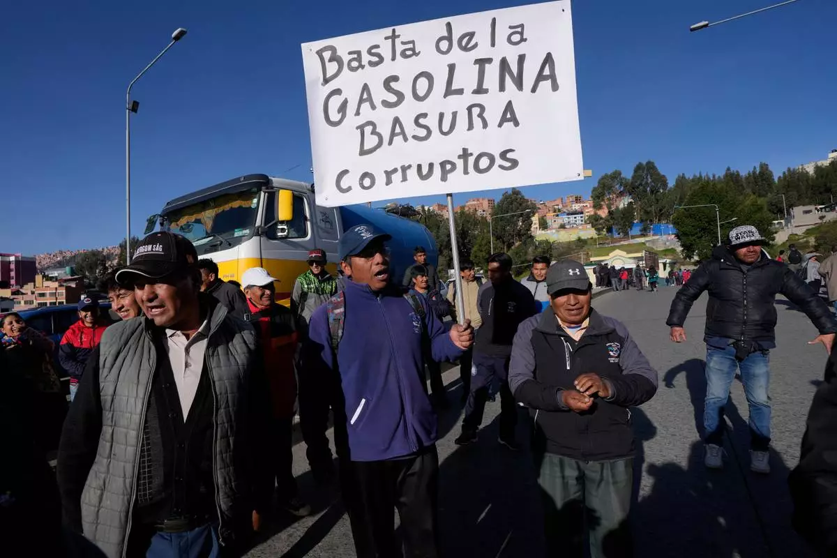 FILE - Public transport drivers protest poor gasoline fuel quality, one holding a sign with a message that reads in Spanish;