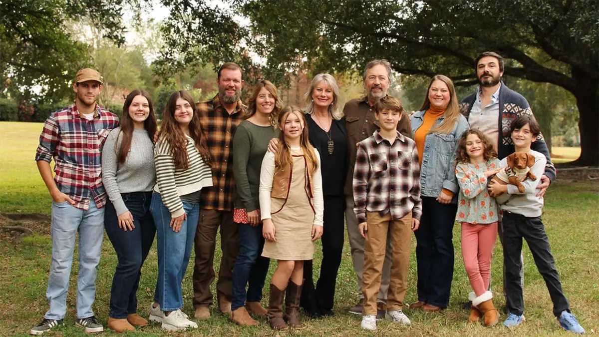 Al and Lisa Robertson standing with their family outdoors.
