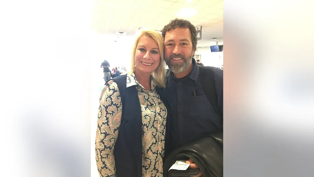 Al and Lisa Robertson posing together lovingly and smiling.