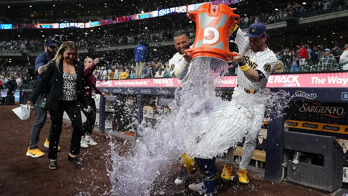 Milwaukee Brewers' William Contreras being doused by Jackson Chourio and Garrett Mitchell on baseball field