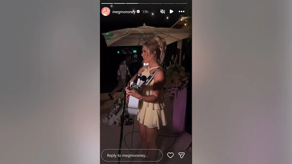 Megan Moroney playing the guitar in a yellow dress in May 2026.
