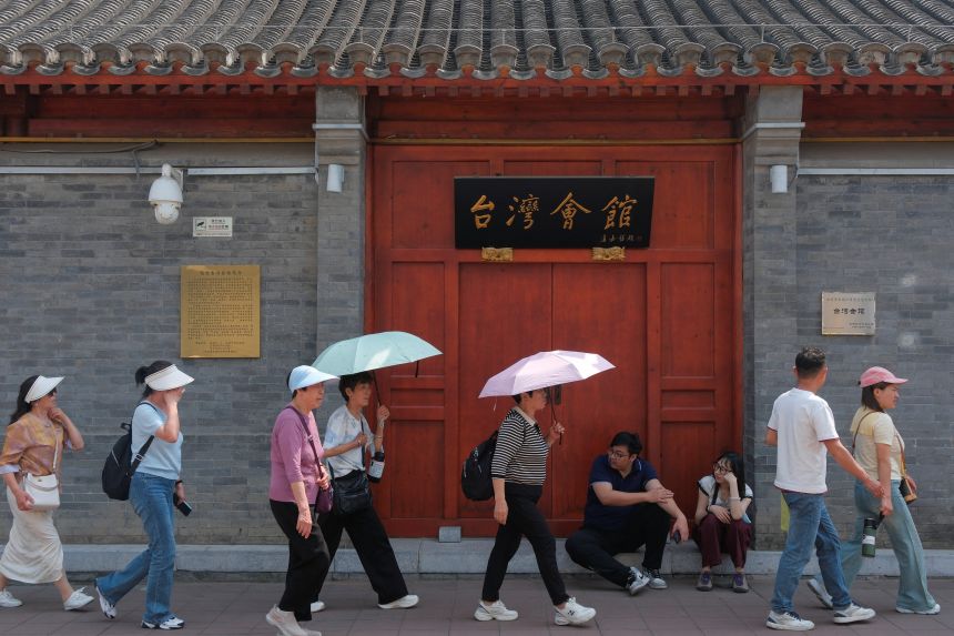 People walk past the Taiwan Assembly Hall, ahead of President Donald Trump’s visit to China, in Beijing, on May 13.