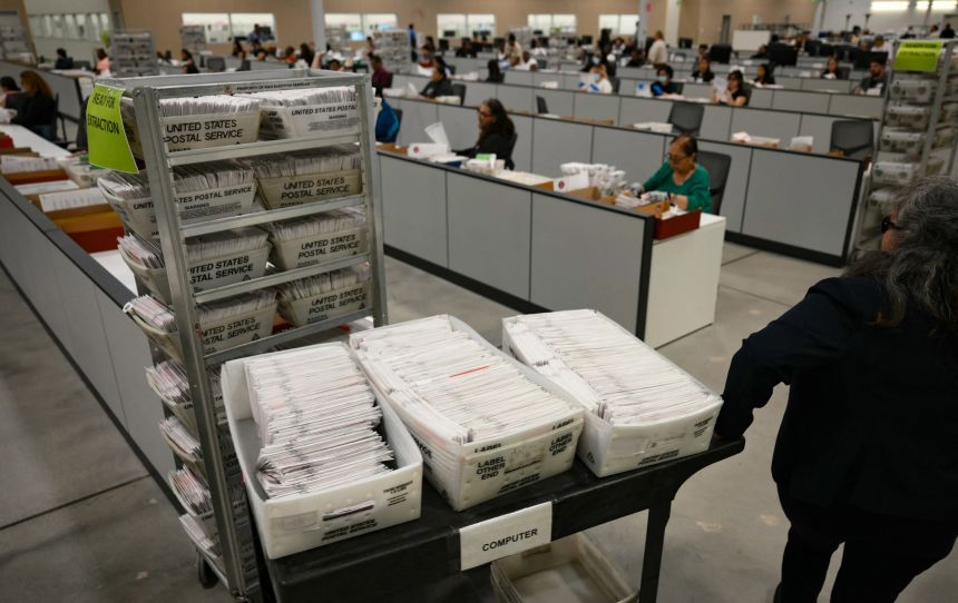An election worker moves mail-in ballots to be organized for tabulation at the Los Angeles County Ballot Processing Center during California's state primary election in the City of Industry, California, on June 2.