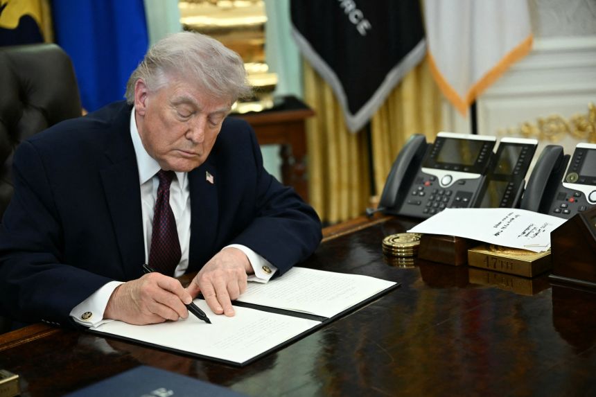 US President Donald Trump signs an executive order cracking down on mail-in voting ahead of midterm elections in the Oval Office of the White House in Washington, DC, on March 31.