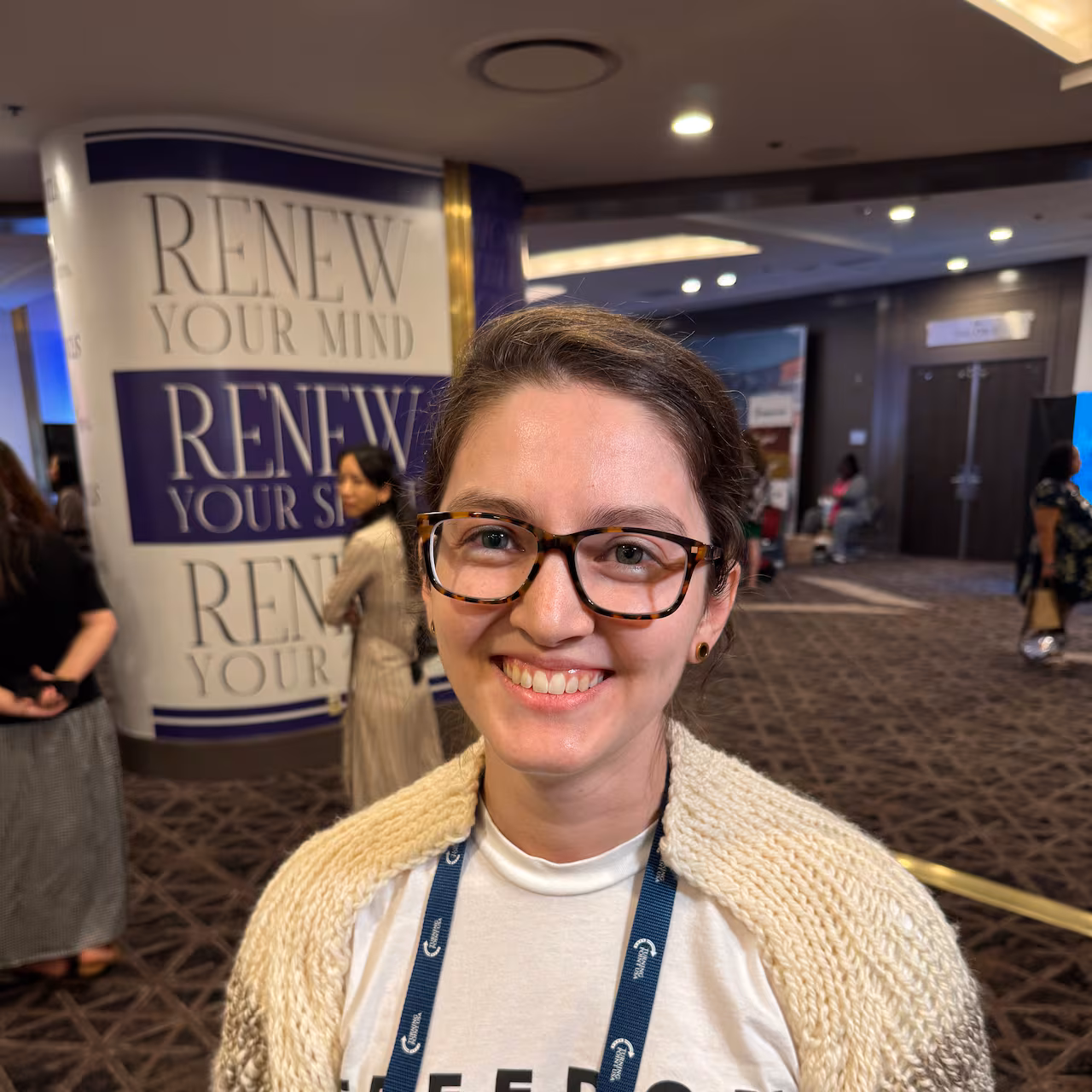 A woman in glasses poses for a photo.