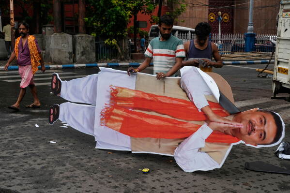 Workers prepare a huge cutout of Suvendu Adhikari, Chief Minister of West Bengal state to fix at a venue ahead of International Yoga Day, scheduled on June 21, in Kolkata, India, Friday, June 19, 2026. (AP Photo/Bikas Das)