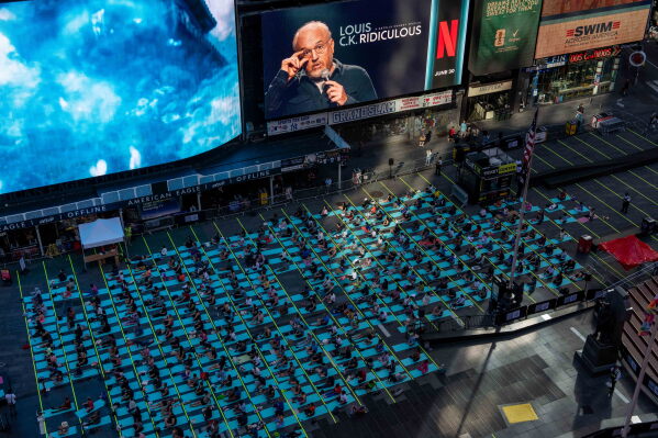 People participate in a mass yoga class during the 