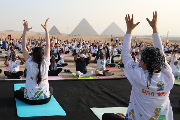 People perform yoga marking the International Yoga Day in front of the historical site of the Giza pyramids, just outside Cairo, Egypt, Sunday, June 21, 2026. (AP Photo)