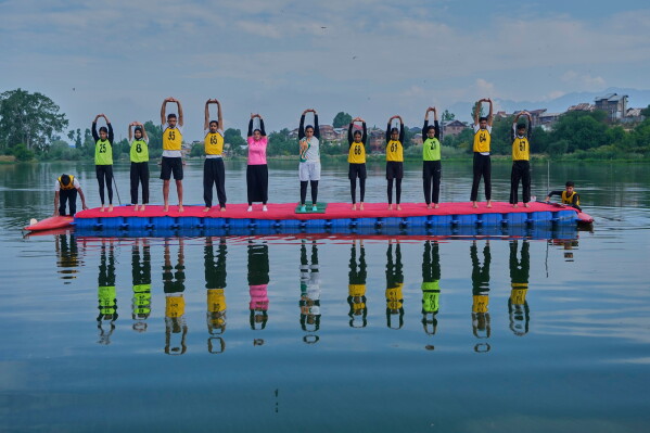 Participants perform yoga during an International Yoga Day event at Pokhrabal Lake in Srinagar, Indian controlled Kashmir, Sunday, June 21, 2026. (AP Photo/Mukhtar Khan)
