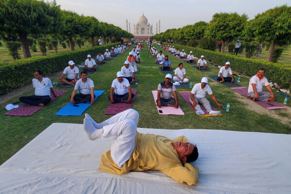 People perform yoga during an International Yoga Day event against the backdrop of the Taj Mahal in Agra, India, Sunday, June 21, 2026. (AP Photo/ Pawan Sharma)