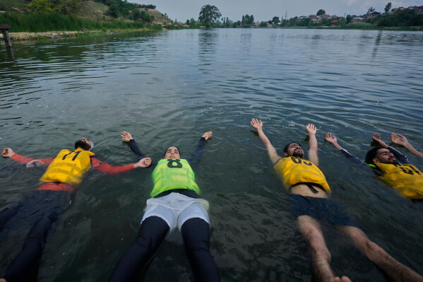 Participants perform yoga during an International Yoga Day event at Pokhrabal Lake in Srinagar, Indian controlled Kashmir, Sunday, June 21, 2026. (AP Photo/Mukhtar Khan)