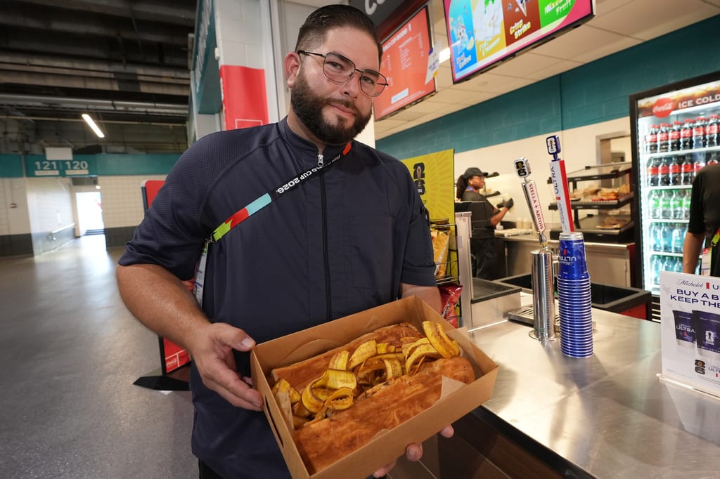 Lázaro Luya, el chef de Sol Cubano, muestra su platillo especial con lechón y mariquitas frescas en el estadio de Miami, el 21 de junio de 2026.