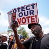 A demonstrator holds a sign saying “PROTECT OUR VOTE!” at a May 16 rally in Montgomery, Ala., responding to the recent U.S. Supreme Court ruling that weakens Voting Rights Act protections against racial discrimination in redistricting.