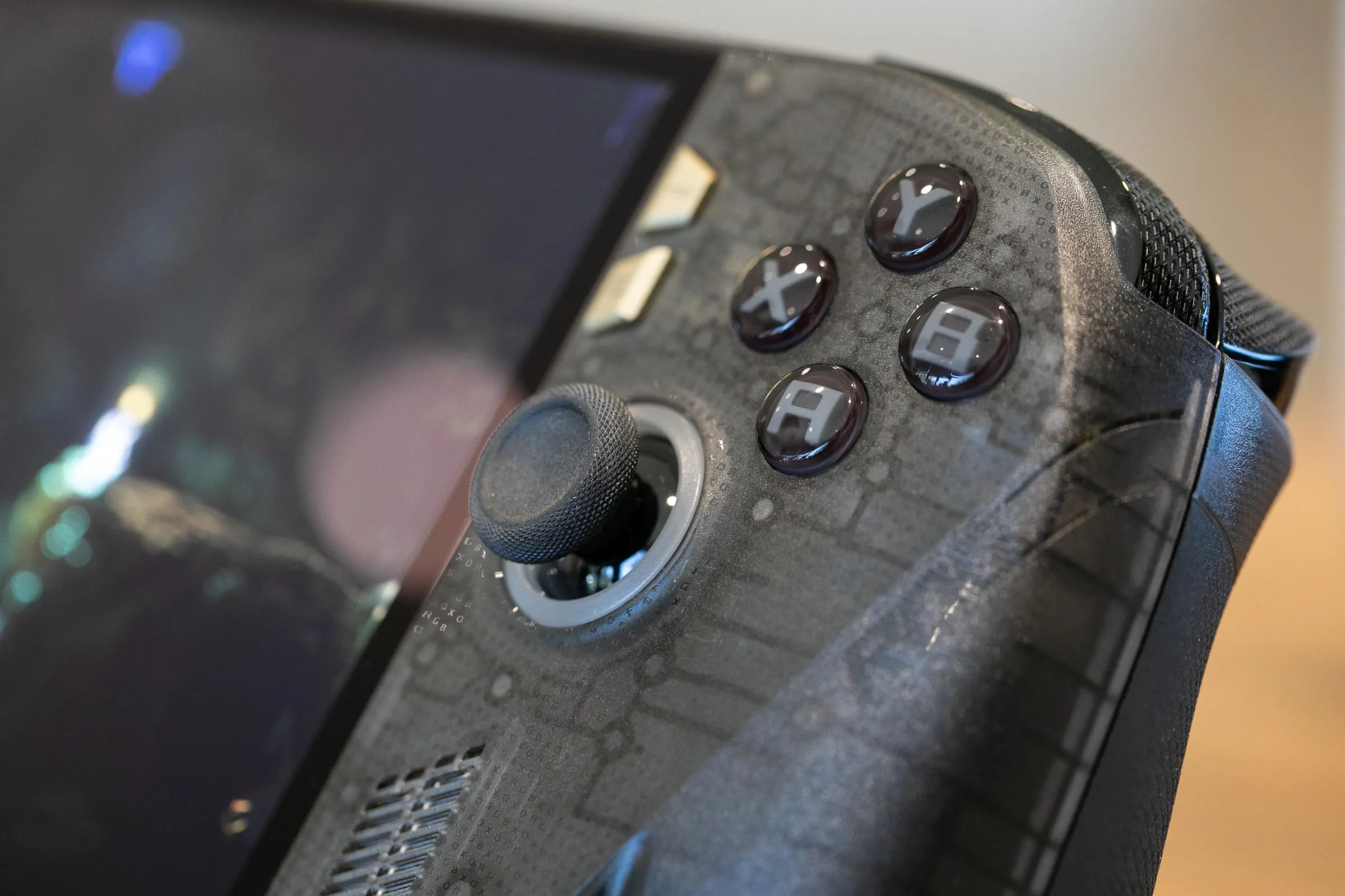 The front right corner of the Ally in shallow focus shows its joystick texture and the height of its abxy buttons. 