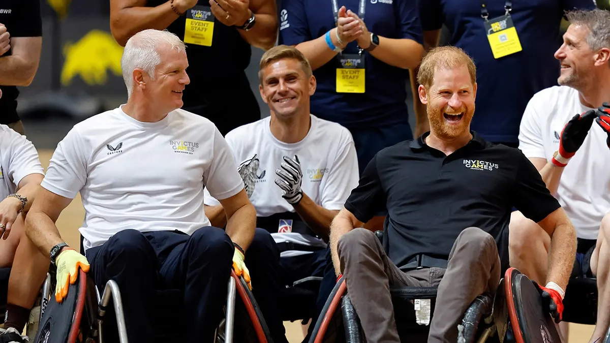Al Carns and Prince Harry play wheelchair rugby in a gymnasium.