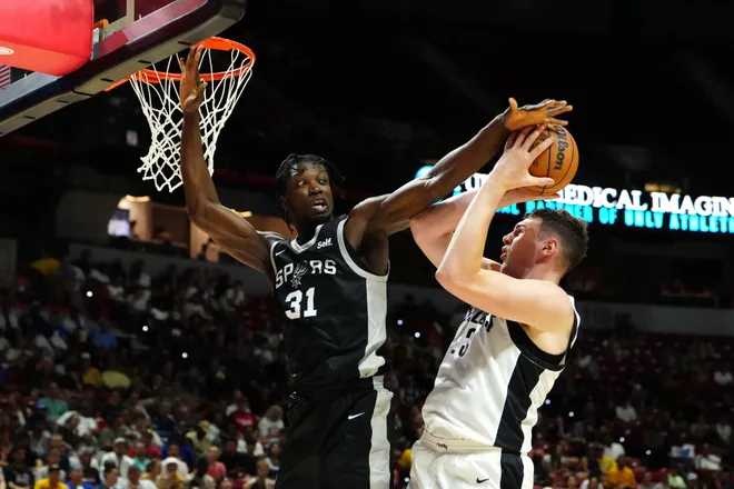 Jul 13, 2024; Las Vegas, NV, USA; San Antonio Spurs forward Nathan Mensah (31) defends against a shot attempt by Portland Trail Blazers center Donovan Clingan (23) during the third quarter at Thomas & Mack Center. Mandatory Credit: Stephen R. Sylvanie-USA TODAY Sports