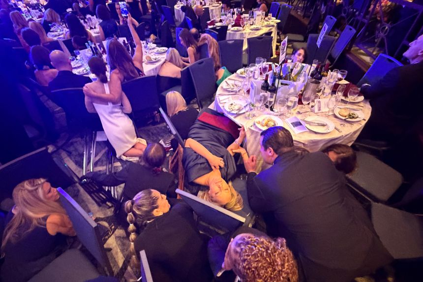 Guests take cover after President Trump and First Lady Melania Trump were rushed out of the White House Correspondents' Association dinner by Secret Service agents.
