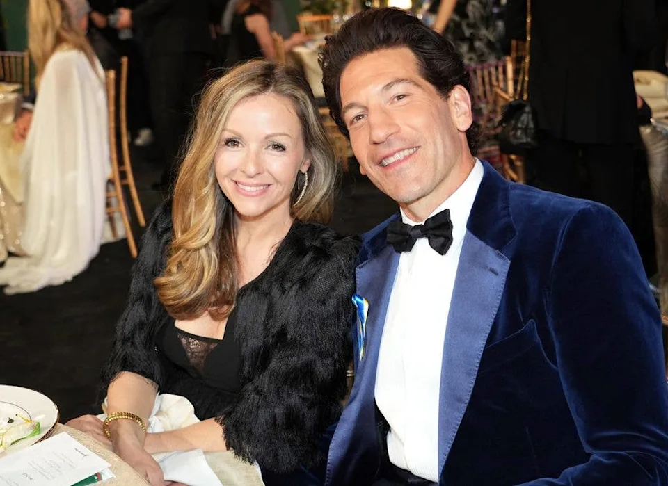Jon Bernthal and his wife Erin Angle smiling sitting at table at event