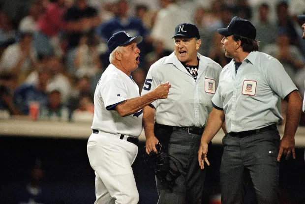 Dodgers manager Tommy Lasorda, left, argues with umpires Jim Quick, center, and Bob Davidson after Quick ejected Lasorda during the ninth inning against the St. Louis Cardinals on Aug. 10, 1995. The Dodgers lost by way of forfeit during the ninth inning after fans repeatedly threw baseballs onto the field. The Cardinals won the game 2-1. (AP Photo/Michael Caulfield)