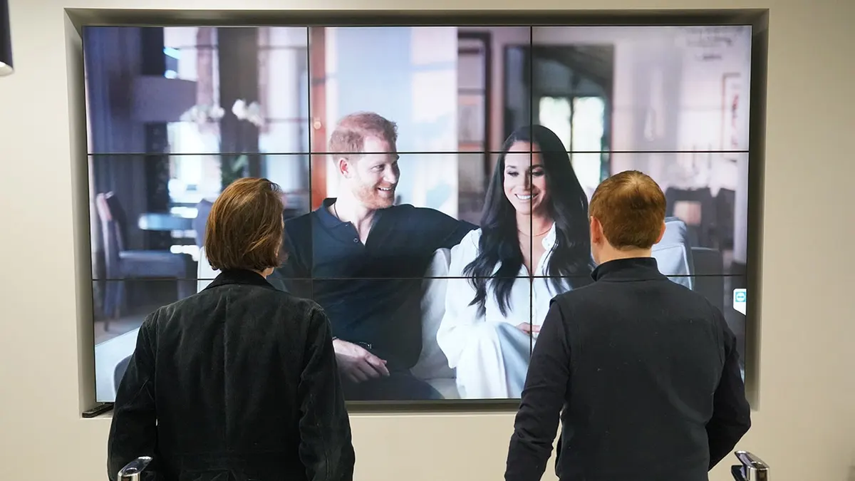 Office workers in London watch the Duke and Duchess of Sussex's documentary on a screen.