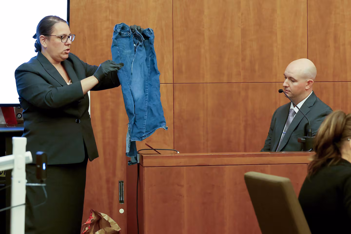 Prosecutor Shanan Buckingham, left, shows a pair of jeans worn by Lindsay Clancy to witness Mass. State Police Sgt. Dan Lawlor, during Clancy's murder trial at Plymouth Superior Court in Plymouth, Mass., Wednesday, Aug. 12, 2026.