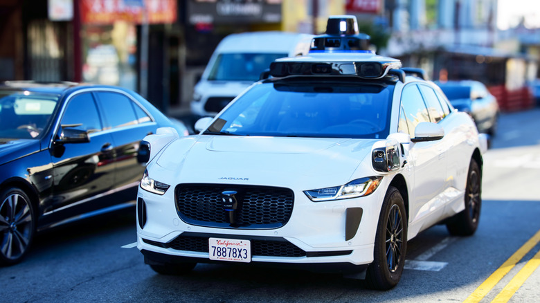 Waymo Jaguar driverless car on urban street.