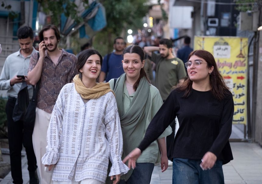 Young Iranian women walk along a sidewalk in downtown Tehran, Iran, on June 15.