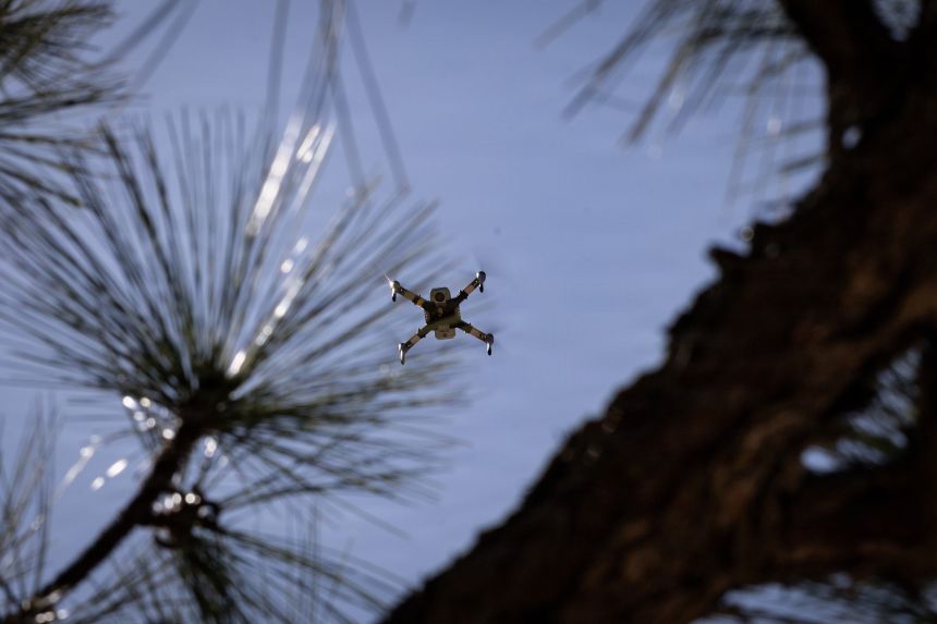 A drone, used as a ground-to-air and air-to-air enemy drone interceptor, hovers above the trees at Fort Bragg, North Carolina, April 23, 2026.