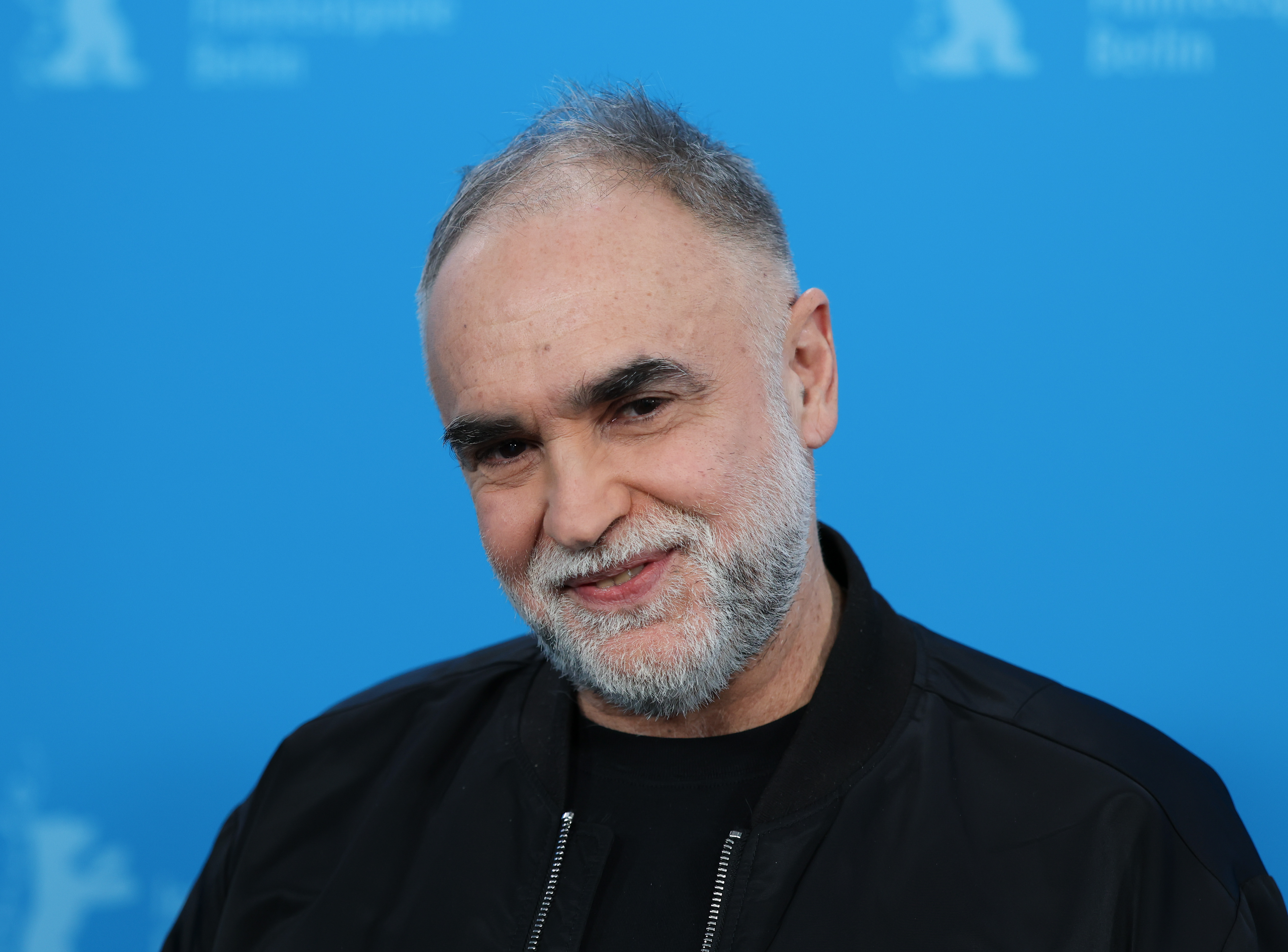 14 February 2026, Berlin: Brazilian director Karim Ainouz stands in front of the blue wall at the photocall for the film