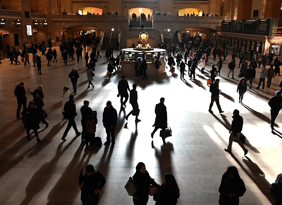 Commuters walk through the morning bright sunlight coming from the 60 feet (18m) high windows in Grand Central Terminal in New York City on March 11, 2019 the first morning after Daylight Savings Time took effect March 10, 2019.