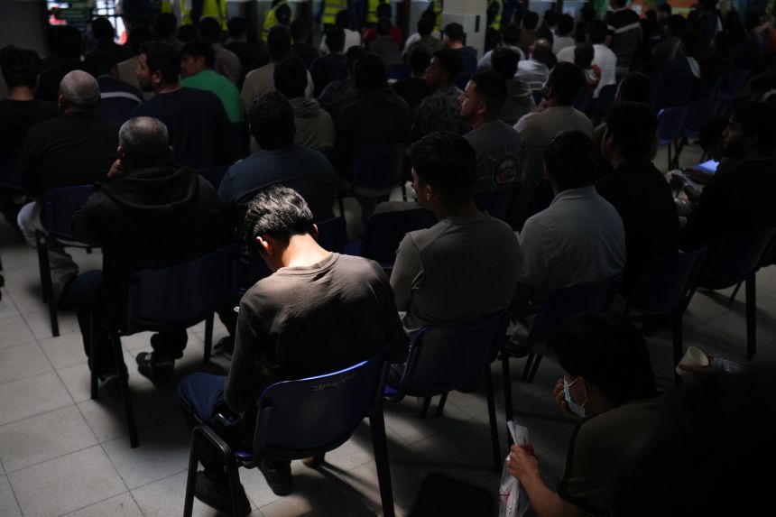 People removed from the US wait inside a processing center at Guatemala City's La Aurora airport on August 21.