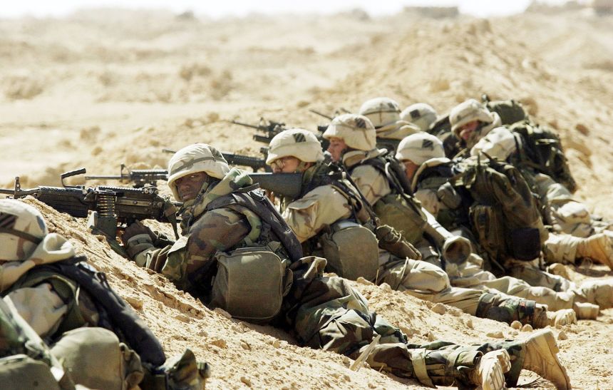A US Army 3rd Division 3-7 Infantry soldiers take cover after taking fire during a search and destroy mission March 27, 2003 near the town of An Najaf, Iraq.